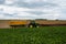 Bossut, Wallon Region, Belgium - Yellow tractor harvesting beets at an agriculture field