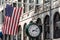 Boston, MA USA - Shopping Mall Store front with american flag waving with a big clock beside it