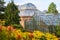 Botanic garden with colorful blooming rhododendrons and more=dern and victorian green houses.