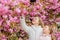 Botany concept. Flowers soft pink clouds. Children enjoy warm spring. Girls posing near sakura. Lost in blossom. Kids on