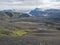 Botnar mountain hut and campsite on Laugavegur hiking trail, green valley in volcanic landscape among lava fields with