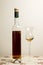Bottle of amber colored fortified wine with tulip shaped cordial glass