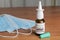 Bottle of anti covid-19 nasal spray made with monoclonal antibodies on a wooden table next to some surgical masks