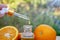 bottle of aromatic essence and fresh orange on the background of nature.