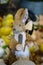 Bottle Brush toy rabbit with determined look on his face holding flowers and a garden spade with easter chicks in background - sel