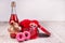 Bottle of champagne, box with red roses ,rustic ribbon, donuts on a wooden surface. Festive congratulations background
