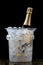 Bottle of Champagne in an ice bucket against a festive background and straw huts