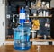 Bottle of clean water 19 liters with blue pomp in the interior of the apartment on the background of the kitchen. Clean and health