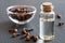 A bottle of clove essential oil with dried cloves