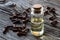 A bottle of clove essential oil with dried cloves on a wooden ba