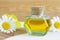 Bottle of cosmetic chamomile oil and wooden hair comb