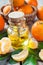 Bottle of essential citrus oil and ripe tangerines in basket