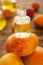 Bottle with essential oil on fresh apricots, closeup