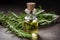 Bottle of essential oil with fresh rosemary twigs. Rosemary oil for hair growth in a small bottle surrounded with fresh rosemary