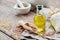 Bottle of fresh linseed oil, wooden scoop of flax seeds on linen cloth. Mortar on background