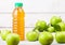 Bottle of fresh organic apple juice with granny smith and british bramley apples in box on wooden background