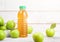 Bottle of fresh organic apple juice with granny smith and british bramley apples in box on wooden background with sun light