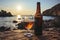 A bottle and a glass of fresh beer on rocky beach on sunny summer evening. Beer on a background of Irish nature. Drinking