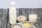 Bottle and glass with milk. Nearby in the container are cereals: buckwheat, rice, corn, barley and oatmeal. On brushed pine boards