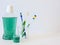 Bottle and glass of mouthwash on bath shelf with toothbrush. Dental oral hygiene concept. Set of oral care products