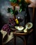 Bottle and glass of red wine, grape and cork on chair. Melon, piece of melon. Pink grape, pear. Still life of food. Dark