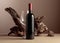 Bottle and glass of red wine with old weathered snag on a beige background