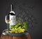 Bottle, glass of white wine and bunch of grapes  on a wooden barrel. 3D vector. High detailed realistic illustration