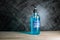 Bottle of hand sanitizer blue gel with ingredient ethyl alcohol 95% on wooden table with dark background