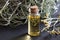 A bottle of helichrysum essential oil with blooming helichrysum