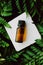 Bottle of herbal essential oil in a green tropical garden, natural scent and organic cosmetics