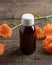 A bottle of herbal tincture with fresh calendula