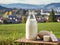 Bottle of homemade village milk against the backdrop of the village. AI