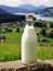 Bottle of homemade village milk against the backdrop of the village. AI