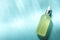 Bottle of hydrophilic oil on light blue background, top view. Space for text