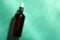 Bottle of hydrophilic oil on turquoise background, top view. Space for text