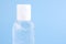 Bottle of instant antiseptic hand sanitizer transparent gel isolated on blue background, no label. Antibacterial, hydro alcoholic