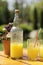 Bottle of limonade on wooden table with small bouquet