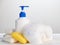 Bottle of liquid soap and blocks of solid soap with soap foam on a light background: the concept of personal hygiene and