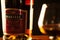Bottle of Martell and a glass on a dark black background, from a close distance, nobody