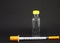 A bottle of medicine insulin and a syringe on a black background. Type 1 diabetes. Close-up with space for inscription