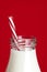 Bottle of Milk with Straw over Vibrant Red Background