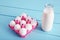 Bottle of milk and white eggs in a pink filler tray on turquoise wooden country kitchen table