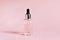 Bottle of moisturizing face oil on a pink background. A professional product for the perfect complexion. Women`s accessories, beau