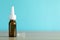 Bottle of nasal spray on table against light blue background, space for text