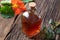 A bottle of nasturtium tincture with fresh Tropaeolum majus leaves and flowers