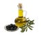 A bottle with olive oil, black olives on a plate and olive branch with leaves on a white background