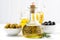 bottle with olive oil and bowls with olives