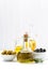 Bottle with olive oil and bowls with olives, vertical