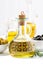 Bottle with olive oil and bowls with olives, vertical closeup