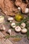 A bottle of olive oil surrounded by mushrooms, rosemary, and garlic. Vegetable set on a brown paper background.